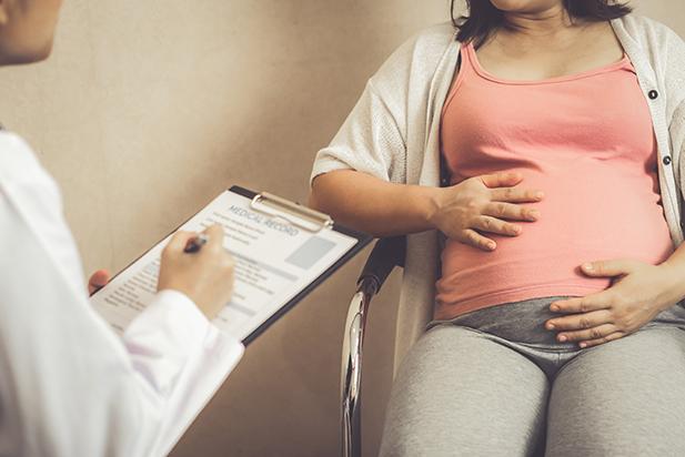 A medical professional assessing a pregnant woman
